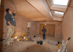 Plaster is drying, floor tiles being laid and wiring being done
