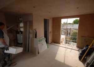 The plastering has been done, the french doors are still to be fitted (note the boiler position at the top of the stairs which will be neatly boxed in with the wall)