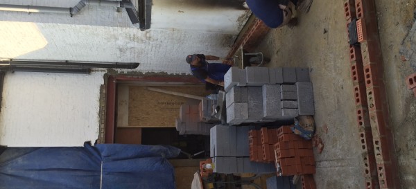 Laying the DPM and first layers of brick on to the concrete slab